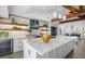Bright kitchen showcasing a large island with quartz countertop, wooden beams, and pendant lighting at 1724 Cheyenne St, Sarasota, FL 34231
