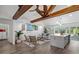 Open-concept living area featuring high ceilings, wood beams, a modern kitchen, and sliding doors to the pool area at 1724 Cheyenne St, Sarasota, FL 34231