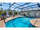 Enclosed pool area with a clear blue swimming pool, brick pool deck and wicker furniture at 1724 Cheyenne St, Sarasota, FL 34231