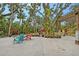 Expansive backyard featuring mature trees, a pergola, seating, a patio, and a playset for outdoor enjoyment at 1788 Palm View Rd, Sarasota, FL 34240