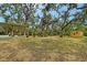 Expansive backyard with mature trees, patio, playground, and a shed, offering endless outdoor possibilities at 1788 Palm View Rd, Sarasota, FL 34240