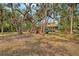 Expansive backyard with mature trees and a fun playset for children to enjoy outdoors at 1788 Palm View Rd, Sarasota, FL 34240