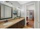 Bathroom featuring a double sink vanity with granite countertops and framed mirrors, illuminated by modern light fixtures at 1788 Palm View Rd, Sarasota, FL 34240