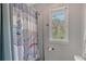 Bathroom featuring window view, toilet, and shower with elephant patterned curtain at 1788 Palm View Rd, Sarasota, FL 34240