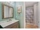 Bright bathroom features framed mirror, a modern sink, and a tub with patterned shower curtain at 1788 Palm View Rd, Sarasota, FL 34240