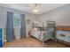 Cozy bedroom featuring a bunk bed, patterned curtains, and hardwood floors at 1788 Palm View Rd, Sarasota, FL 34240