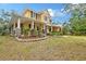 Charming two-story home featuring colorful landscaping and an inviting front porch at 1788 Palm View Rd, Sarasota, FL 34240