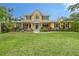 Charming two-story home featuring a landscaped front yard, manicured lawn, and inviting covered porch at 1788 Palm View Rd, Sarasota, FL 34240