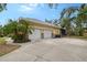 Spacious two-car garage featuring white doors and a large concrete driveway at 1788 Palm View Rd, Sarasota, FL 34240