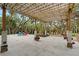 Beautifully landscaped backyard featuring a concrete patio, pergola with string lights, seating, and mature trees at 1788 Palm View Rd, Sarasota, FL 34240