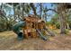 Outdoor play area with a large wooden playset, swings, and multiple slides at 1788 Palm View Rd, Sarasota, FL 34240
