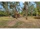 Backyard featuring a wooden playset with swings and slides, surrounded by trees at 1788 Palm View Rd, Sarasota, FL 34240