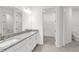 Well-lit bathroom with double vanity, granite countertops, and walk-in closet access at 18016 Cherished Loop, Bradenton, FL 34211