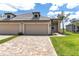 Charming exterior view of a two-car garage home with a beautiful stone driveway and manicured lawn at 18016 Cherished Loop, Bradenton, FL 34211