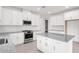 Bright kitchen boasts white cabinets, granite countertops, stainless steel appliances, and a large island at 18016 Cherished Loop, Bradenton, FL 34211