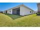 View of a backyard with green grass and white exterior at 18525 Midsummer Pl, Venice, FL 34293