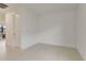 Clean, empty bedroom with neutral tile flooring, white walls and a large door at 18525 Midsummer Pl, Venice, FL 34293