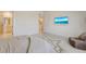 Minimalist bedroom with modern TV and en suite bathroom featuring recessed lighting and tile flooring at 18525 Midsummer Pl, Venice, FL 34293