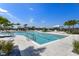 Sparkling community pool with a relaxing area, featuring sun loungers and lush landscaping at 18525 Midsummer Pl, Venice, FL 34293