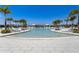 Relaxing community pool area featuring inviting lounge chairs and shade umbrellas, surrounded by palm trees at 18525 Midsummer Pl, Venice, FL 34293