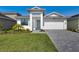 Inviting single Gathering home with a well manicured lawn, stone driveway, and eye catching plants at 18525 Midsummer Pl, Venice, FL 34293