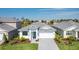 Charming single Gathering home with a well manicured lawn, stone driveway, and beautiful plants at 18525 Midsummer Pl, Venice, FL 34293