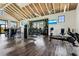 Bright gym with modern equipment, mounted TVs, and tropical wallpaper accents at 18525 Midsummer Pl, Venice, FL 34293