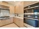 Modern kitchen showcasing stainless steel appliances and light wood cabinets with white countertops at 18525 Midsummer Pl, Venice, FL 34293