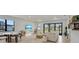 Spacious living room with a TV, dining table, and large windows letting in lots of natural light at 18525 Midsummer Pl, Venice, FL 34293