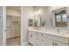 Bright bathroom with double vanity, white quartz countertops, framed mirrors, and a walk-in closet at 1907 Woodleaf Hammock Ct, Bradenton, FL 34211
