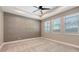 Tranquil bedroom with neutral decor, tray ceiling, a ceiling fan, and ample natural light from multiple windows at 1907 Woodleaf Hammock Ct, Bradenton, FL 34211