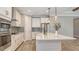 Gourmet kitchen with gray tile backsplash, pendant lighting, and a large quartz island with breakfast bar at 1907 Woodleaf Hammock Ct, Bradenton, FL 34211