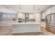 Bright kitchen with a large center island, pendant lighting, stainless steel appliances, and ample cabinet space at 1907 Woodleaf Hammock Ct, Bradenton, FL 34211