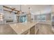 Open-concept kitchen boasting a central island, coffered ceilings, and seamless flow to the living area and outdoor pool at 1907 Woodleaf Hammock Ct, Bradenton, FL 34211