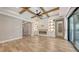 Living room with beamed ceiling, electric fireplace, custom shelves, and access to the patio at 1907 Woodleaf Hammock Ct, Bradenton, FL 34211