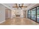 Open-concept living room featuring tray ceiling, fireplace, and access to the outdoor kitchen at 1907 Woodleaf Hammock Ct, Bradenton, FL 34211