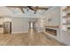 Bright living room with wood-look tile, fireplace, custom cabinets, and stainless steel appliances at 1907 Woodleaf Hammock Ct, Bradenton, FL 34211