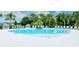 Inviting community pool area with ample seating and lush landscaping for relaxation at 1907 Woodleaf Hammock Ct, Bradenton, FL 34211