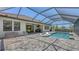 Enclosed pool area with in-pool loungers, outdoor grill, and covered patio at 1907 Woodleaf Hammock Ct, Bradenton, FL 34211
