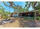 Expansive backyard with fire pit, mature trees, and a view of the screened-in back patio at 209 29Th Nw St, Bradenton, FL 34205
