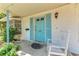 Charming front porch detail with a rocking chair, blue door and inviting decor at 209 29Th Nw St, Bradenton, FL 34205