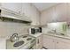 A vintage kitchen featuring a green stove, matching range hood, and retro cabinets at 209 29Th Nw St, Bradenton, FL 34205