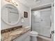 White bathroom with marble countertops, tiled floors and a glass shower at 210 Santa Maria St # 244, Venice, FL 34285