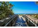 View of a beach boardwalk leading to the ocean, with railings for safety at 210 Santa Maria St # 244, Venice, FL 34285