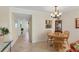View of the dining area with a wooden table set and bright hallway at 210 Santa Maria St # 244, Venice, FL 34285