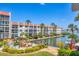 An exterior view of the condo building on the water, surrounded by lush landscaping and palm trees at 210 Santa Maria St # 244, Venice, FL 34285