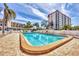 Resort-style pool surrounded by brick pavers, palm trees, and lounge chairs creating a relaxing oasis at 210 Santa Maria St # 244, Venice, FL 34285