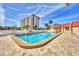A serene pool area is surrounded by lush landscaping and the community's residential building at 210 Santa Maria St # 244, Venice, FL 34285