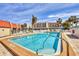 Community pool featuring ample lounge chairs, palm trees, and a view of the Bella Costa condo complex at 210 Santa Maria St # 244, Venice, FL 34285