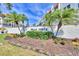Sign at the entrance to Bella Costa condos, featuring mature landscaping and tropical palm trees at 210 Santa Maria St # 244, Venice, FL 34285